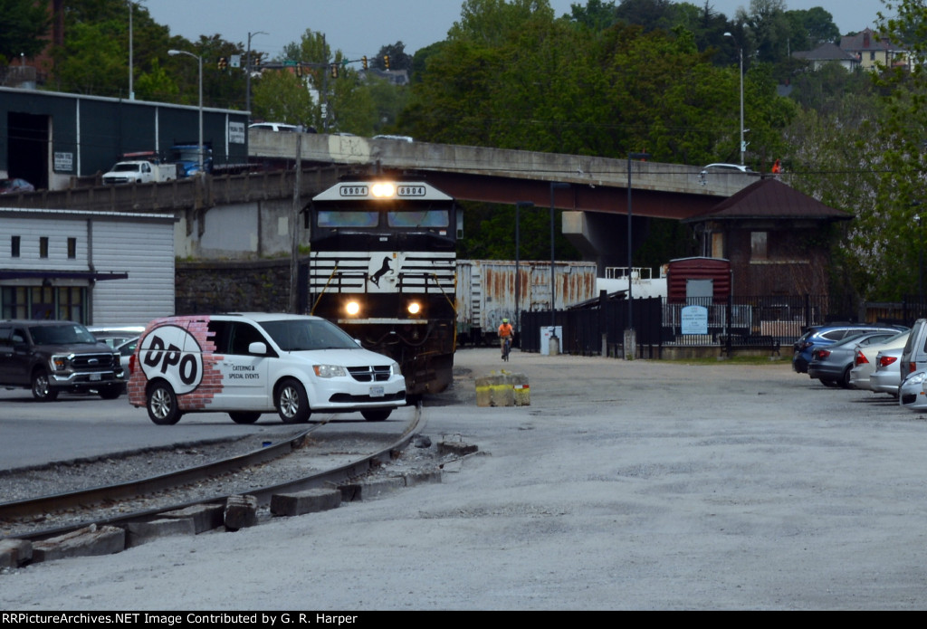 The Depot Grille's van crosses in front of NS E19.  Not to worry.  the E19 is stationary as his conductor walks the train prior to departure